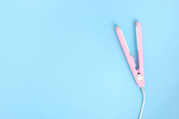 Hair straightener on blue background.