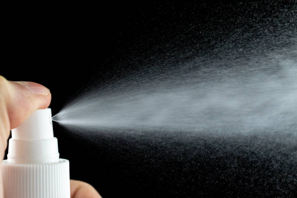istock Aerosol splash background. Liquid water spray mist from perfume bottle isolated on black. 1226995596