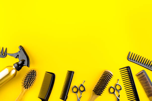 istock Hairdressing instruments. Combs, scissors on yellow table top view frame copy space 1226995650