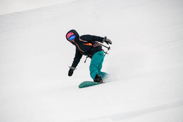istock Girl snowboarder moving down in snow powder 1226997382
