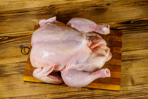 istock Raw whole chicken on a wooden table. Top view 1227000812