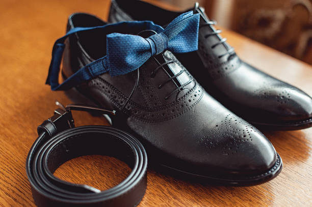 primo tempo di accessori moderni per l'uomo. papillon blu, scarpe in pelle e cintura. - shoe groom wood luxury foto e immagini stock