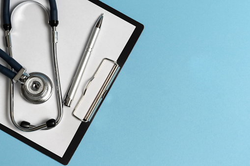 Paper tablet and stethoscope on a blue background. Medicine concept.