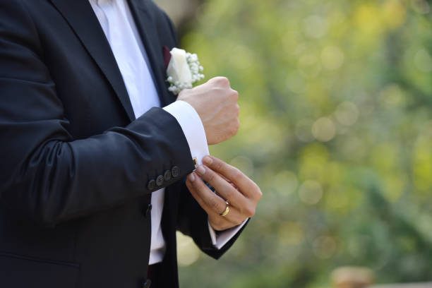 istock Groom touches cufflinks in park 1227005133