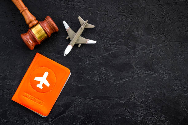 istock Flight cancellation. Airplane, passport, judge gavel on black desk top-down copy space 1227005563