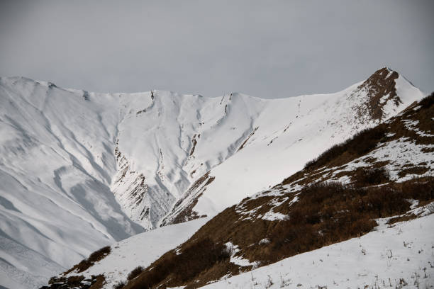 istock Charming view of snow-capped mountain peaks and sky covered with clouds. 1227005606