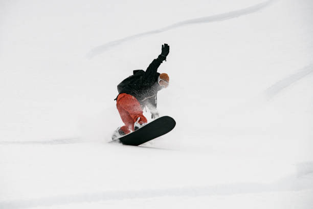 istock Active young man snowboarder riding on slope. 1227007065