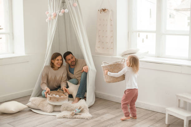 nettes baby mädchen mit ihren eltern spielen in einem minimalistischen kinderzimmer. - child playroom parent indoors stock-fotos und bilder