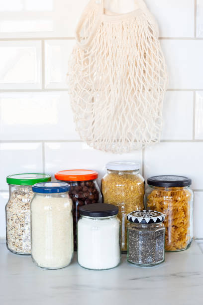 istock Zero waste plastic-free concept at home, different food in reused glass jars and empty mesh bag on the kitchen, vertical 1227007826