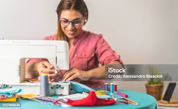 Happy Latin Tailor Seamstress Woman Sewing With Machine Homemade Medical Face Mask For Preventing And Stop Corona Virus Spreading Textile Industry And Covid19 Healthcare Concept Stock Photo - Download Image Now