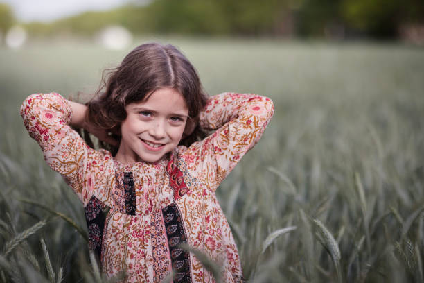 istock Kid smiling when standing in wheat field 1227008784