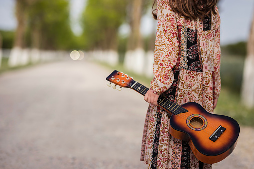 Girl with ukulele guitar in her hand leaving