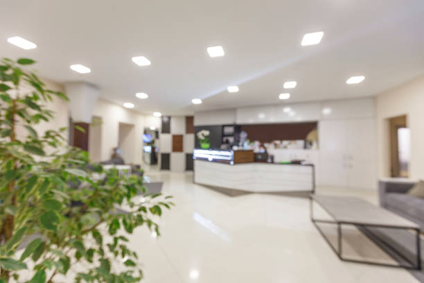 Empty hall with reception and waiting area with sofa Empty hall with reception and waiting area with sofa and armchair, no people, copy space, blurred motion medical office lobby stock pictures, royalty-free photos & images