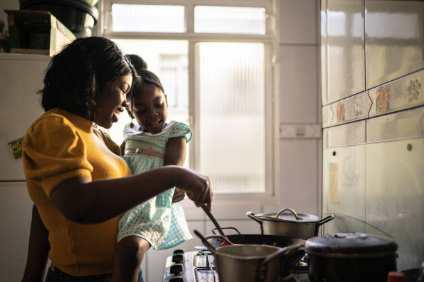 istock Mother cooking at home while holding her daughter 1227013229