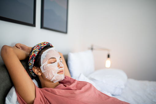 Young Latin woman applying face mask