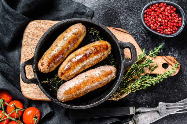 istock Pork sausages in a cast-iron pan. Black background. Top view 1227017204