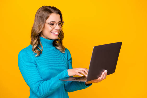 istock Photo of attractive charming wavy lady hold modern technology notebook reading corporate report online email wear specs blue turtleneck isolated bright yellow color background 1227017385