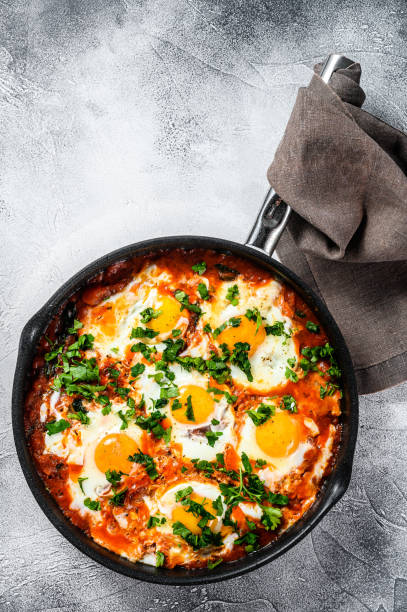 istock Breakfast with Fried eggs, tomatoes. Shakshuka in pan. Turkish  traditional dishes. Gray background. Top view. Copy space 1227017759