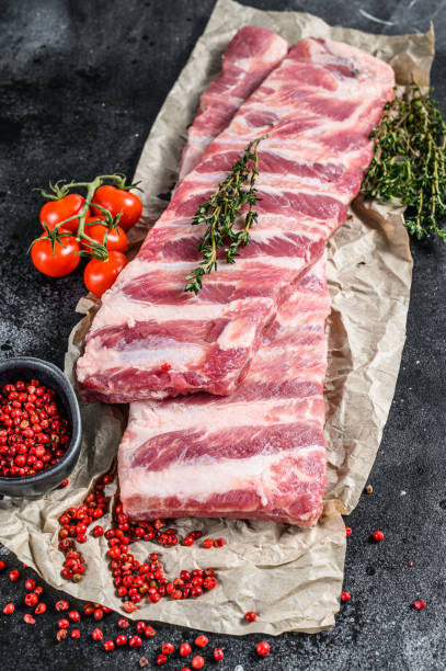 istock Fresh raw lamb spare ribs with spices and herbs. Black background. Top view 1227018519