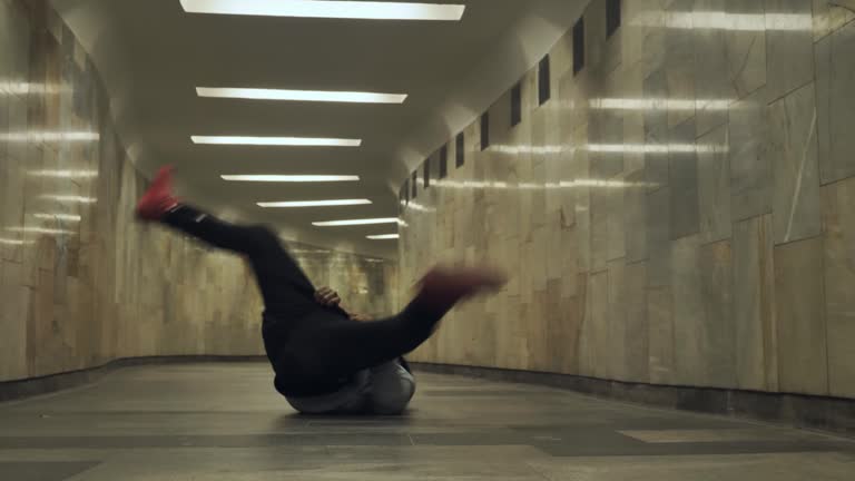 Black man dancing hip-hop in an underground crossing