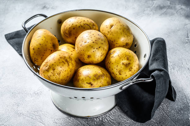 istock Organic yellow potatoes in a colander. Gray background. Top view 1227018667