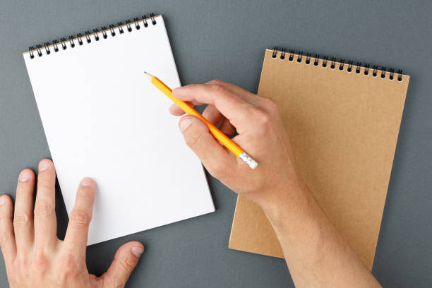 istock Notebook clear page and male hands with pencil. 1227019840