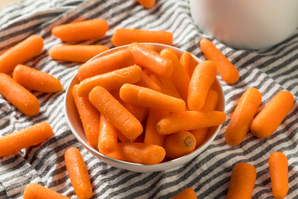 carottes de bébé biologiques crues - baby carrot photos et images de collection