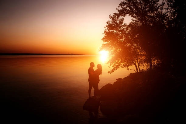 istock couple in love back light silhouette at lake orange sunset 1227021836