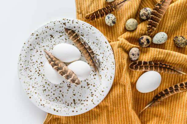 istock Chicken and quail eggs and feathers background.  White background. Top view 1227022637