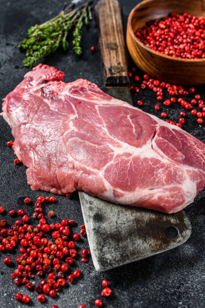 istock Raw pork marbled steak on a meat cleaver. Black background. Top view 1227022805