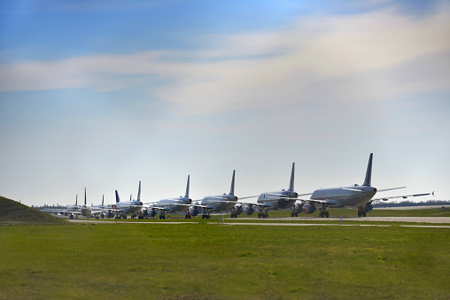 Multiple grounded airplanes parked on the runway. Worldwide the airline industry has been taking a hard financially hit due to the Covid - 19, Corona Virus Pandemic.