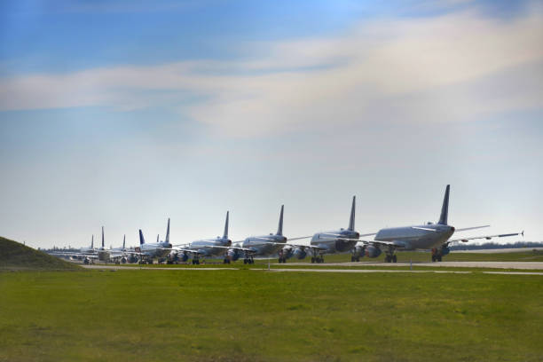 Grounded Airplane, Covid - 19 Corona Pandemic Multiple grounded airplanes parked on the runway. Worldwide the airline industry has been taking a hard financially hit due to the Covid - 19, Corona Virus Pandemic. stranded stock pictures, royalty-free photos & images