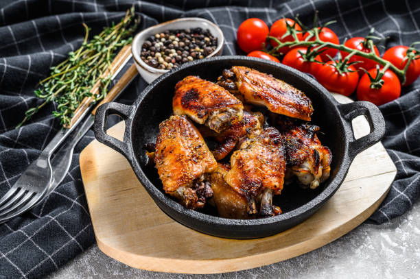 istock Baked glazed chicken wings in a pan. Gray background. Top view 1227023300
