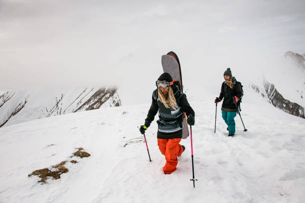 istock Two travellers with snowboards climbing on mountain 1227024131