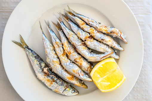 Freshly grilled sardines served with lemon. Torremolinos, Costa del Sol, Andalusia, Spain