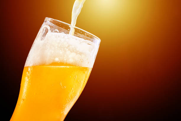 istock Beer pouring into a glass on the dark background 1227026441
