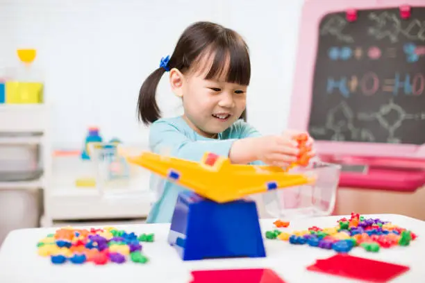 Photo of toddler girl play balance toy for homeschooling