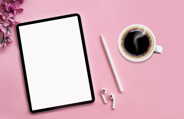 istock Modern tablet, white wireless headphones with coffee on a pink background. 1227028337