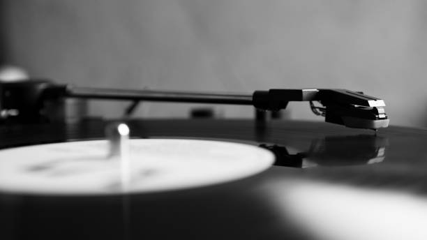 istock Black and white vinyl needle stylus on rotating black vinyl disk with copy space. Turntable vinyl record player. 1227029646