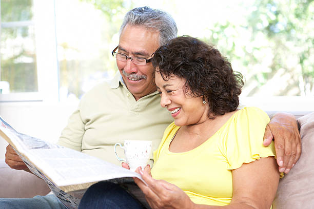 一緒に年配のカップルリーティング紙 - senior adult relaxation sofa reading ストックフォトと画像