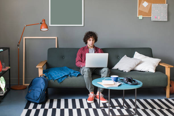 istock Learning and Studying from Home: a College Student Attending an Online Course by Using his Laptop Computer 1227031545