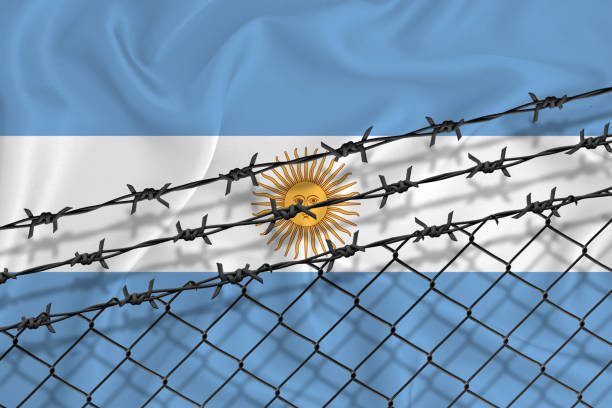 istock Developing Argentina Flag, mesh fence and barbed wire. Concept of isolation of emigrants. With place for your text. 1227032681