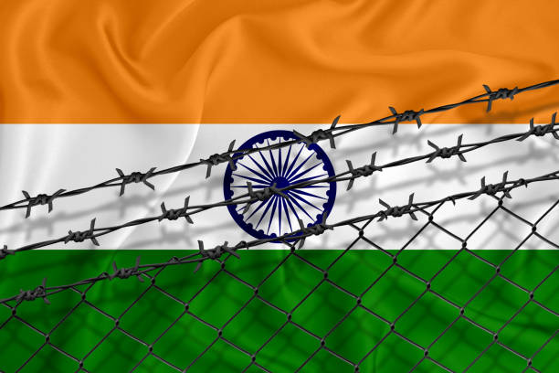 istock Developing India Flag, mesh fence and barbed wire. Concept of isolation of emigrants. With place for your text. 1227032781