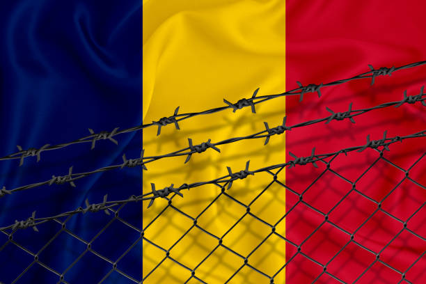 istock Developing Romania Flag, mesh fence and barbed wire. Concept of isolation of emigrants. With place for your text. 1227032946