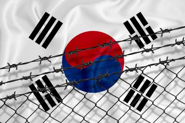 istock Developing South Korean Flag, mesh fence and barbed wire. Concept of isolation of emigrants. With place for your text. 1227032970