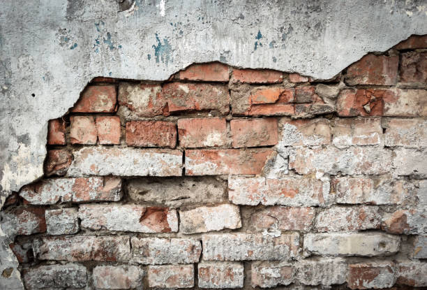 istock Wall texture background, rough damaged stucco or plaster over old brickwork. Dirty brick wall of building, fragment of vintage broken surface 1227033846