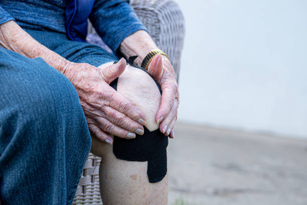 Elderly Senior Caucasian Woman's Knee Joint Arthritis Pain In Midday Outdoors in the Summer Elderly Senior Caucasian Woman's Knee Joint Arthritis Pain In Midday Outdoors in the Summer artificial knee photos stock pictures, royalty-free photos & images
