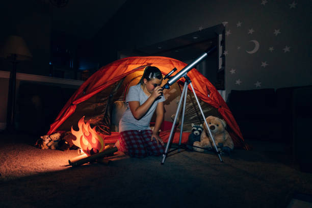 istock Girl Exploring with Telescope Indoors 1227034939
