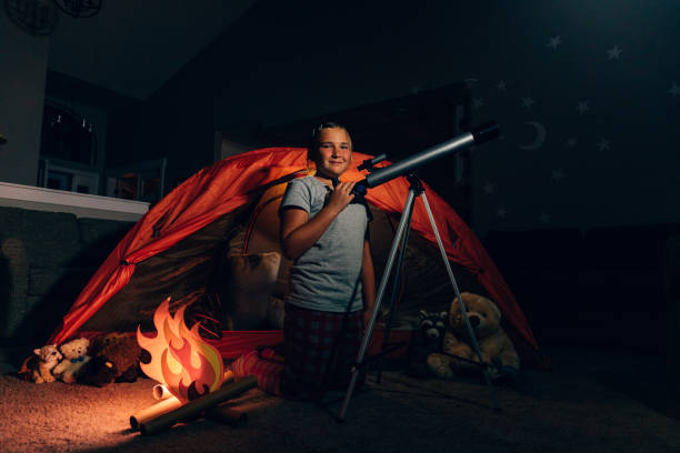 istock Girl Exploring with Telescope Indoors 1227035109
