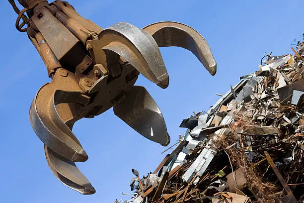 Crane Grabber close-up and rusty metal heap in the docks